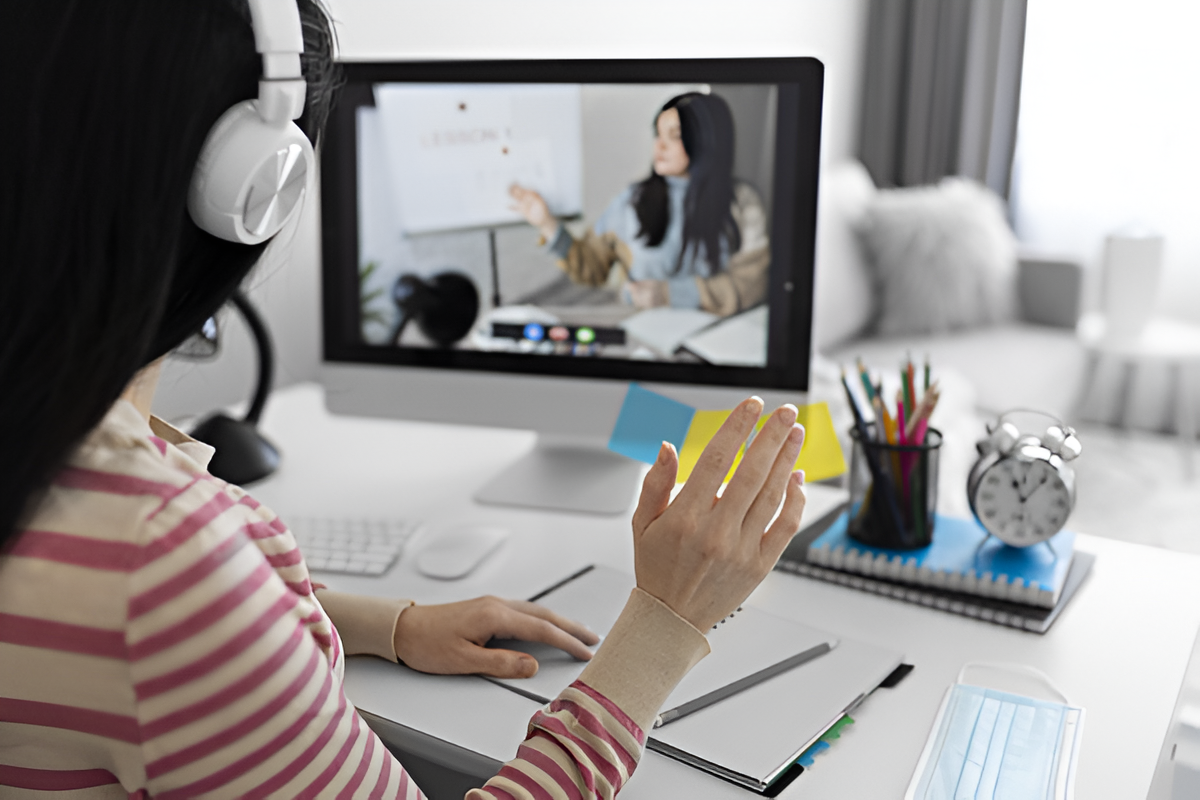 Estudante acompanhando aula virtual na tela de um computador.